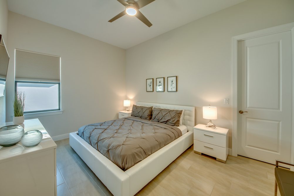 Bedroom with white furniture and cream colored duvet covers in Villa Aesthetic