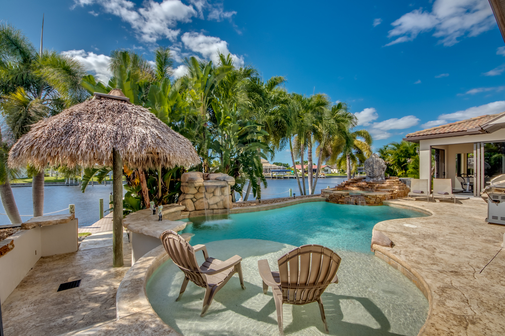 Pool mit Sonnenstühlen in der Villa Dolphin’s Surf