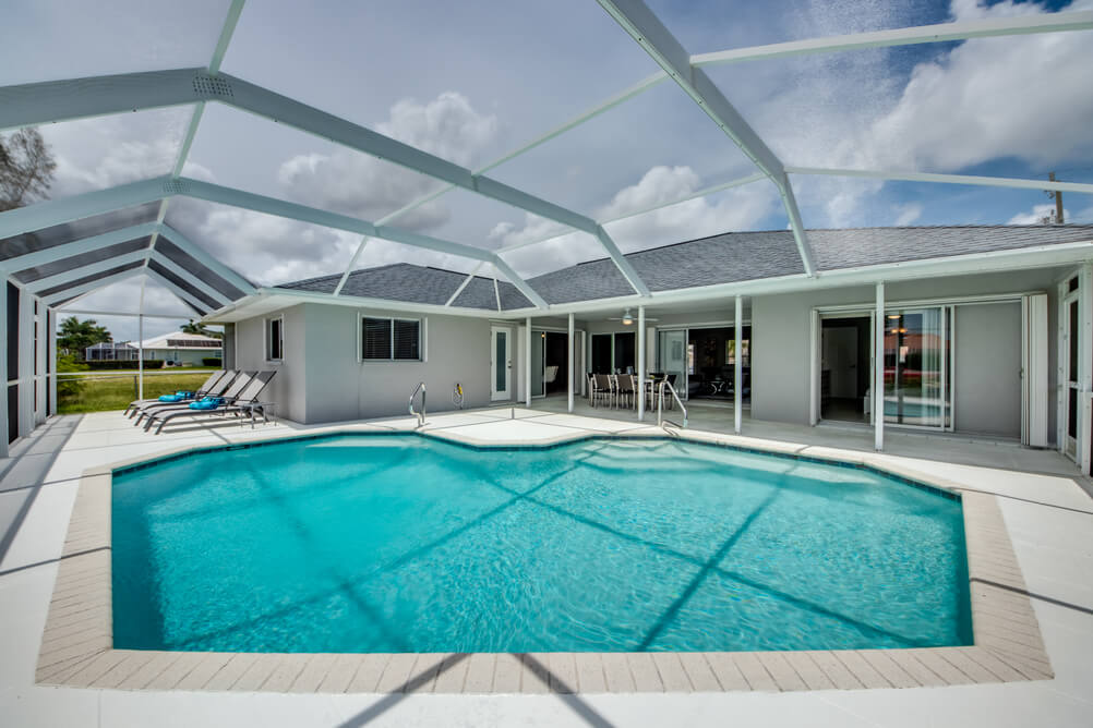 Pool mit Sonnenliegen und Ausblick auf die Villa Sunset Avenue